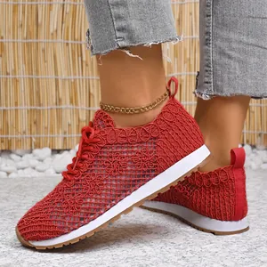 Close-up view of red floral mesh breathable sneakers on foot with denim jeans and anklet