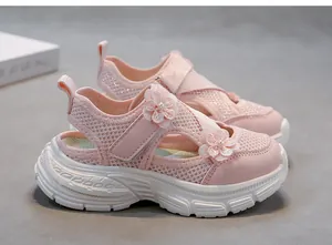 Close-up of pink mesh girl's sandals featuring 3D floral accents and white thick sole.