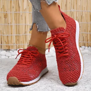 Macro detail of women's red mesh breathable low-top sneakers with golden anklet.