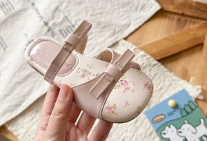 Detail shot of pink girls' bow sandals featuring delicate floral print insoles.