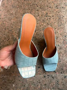 Vue détaillée de la texture crocodile bleue sur ces sandales compensées à bout carré chic.