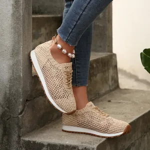 Detailed view of beige breathable mesh low-top sneakers worn on concrete stairs