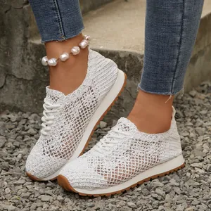 Close-up of white breathable mesh lace-up sneakers on gravel background with pearl anklet detail