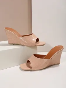Vue détaillée de sandales compensées nude effet croco avec une bride large et un bout carré.