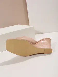 Vue détaillée d'une sandale compensée nude avec texture croco et semelle antidérapante.