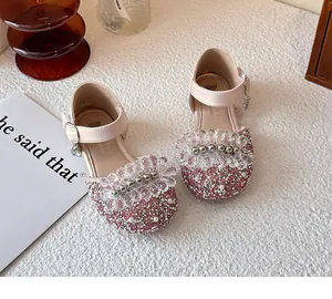 Close-up of sparkling pink girls' shoes featuring intricate crystal flower and pearl details