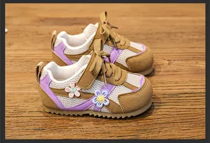 Close-up view of breathable mesh children's sneakers with cute floral embroidery