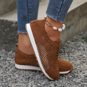 Close-up of brown breathable crochet mesh sneakers with white flat soles.