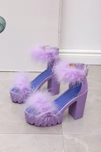 Close-up detail of purple chunky heel sandals featuring soft faux fur straps and buckle