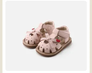 Adorable pink baby girl closed-toe sandals featuring checkered bows and soft soles.