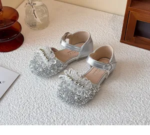 Detail showing silver sparkly girl's princess shoes with crystal and pearl decorations