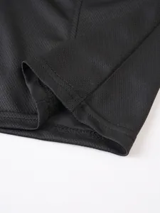 Macro view of black mesh fabric hem with durable double-stitch detailing.