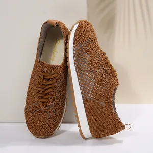 Close-up view of brown breathable mesh lace-up sneakers for women featuring white soles
