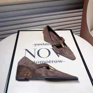 Detail of brown suede Mary Jane wedge shoes with rhinestone-studded heels
