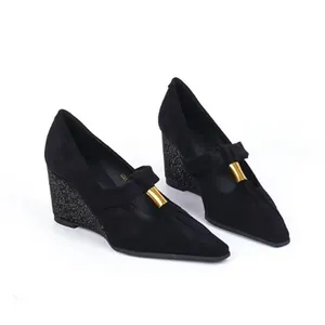 Detailed view of elegant black suede pointed toe wedge pumps featuring gold metal buckle