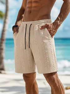 Detailansicht der beigen Herren-Shorts mit Zopfmuster und Kordelzug am sonnigen Strand