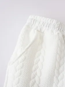 Detailansicht der weißen Herren-Shorts mit einzigartiger Zopfstrick-Jacquard-Struktur und Bund.