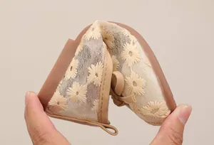 Close-up of flexible beige mesh girls princess shoes with flower embroidery details.