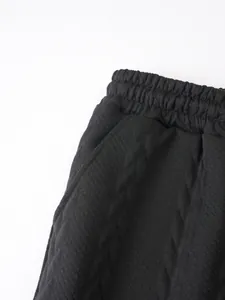 Detailaufnahme der schwarzen Jacquard-Shorts für Herren mit Gummibund und praktischer Tasche.