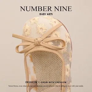 Detailed close-up of girls beige hollow-out princess shoes with floral embroidery