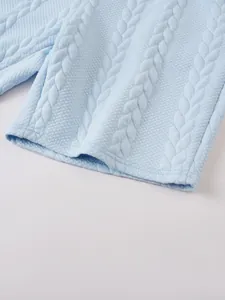 Detaillierte Nahaufnahme hellblauer Herren-Shorts mit aufwendiger Zopfstrick-Struktur