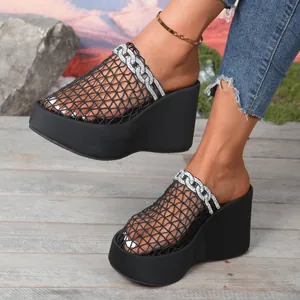 Gedetailleerd zijaanzicht van zwarte mesh sleehak sandalen met een strass ketting