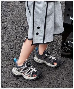 Boys' sporty closed-toe sandals shown on gravel surface in summer outdoor setting