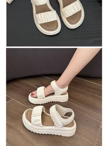 Detailed view of girls' stylish beige platform beach sandals with ruffled straps.