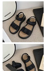 Detail view of stylish black girls' sandals with ruffled strap and soft sole design