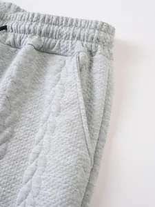 Detailaufnahme des grauen Jacquard-Stoffes und der Seitentasche der Herren-Kordelzug-Shorts