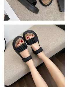 Detailed view of fashionable girls' black ruffled sandals with soft tan cushioned footbed