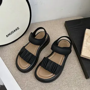 Stylish girls' summer sandals featuring black ruffled straps and soft beige insoles