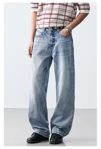 Detail view showing the relaxed fit and light blue wash of these straight denim jeans.