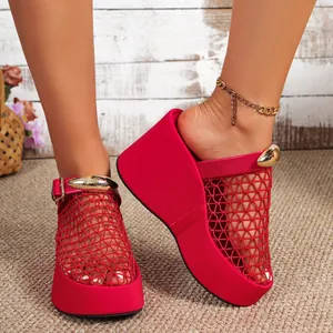 Detailweergave van rode mesh sleehaksandalen met plateauzool en gouden gespen