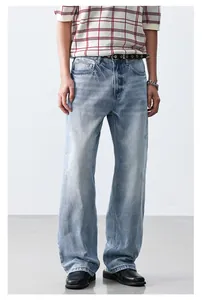 Detail view of light blue washed straight-leg denim jeans in a loose-fit style