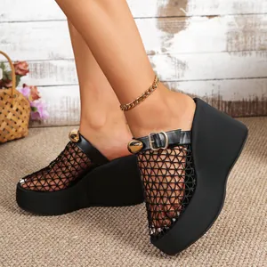 Detailopname van zwarte mesh sleehak sandalen met een chique goudkleurige gesp