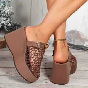 Close-up van bruine mesh sleehak sandalen met een gouden gesp en een hoog plateau.