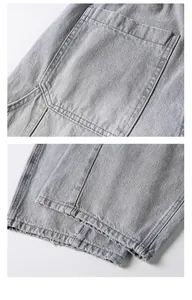 Vue détaillée de la poche arrière et de l'ourlet d'un jean en denim délavé gris