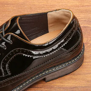 Primer plano detallado de zapatos brogue en charol negro con ricas perforaciones
