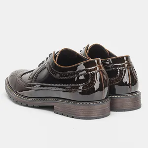 Primer plano de la parte trasera de zapatos brogue de charol con detalles de perforaciones