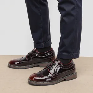 Primer plano de zapatos Brogue de charol burdeos para hombre con detalles clásicos
