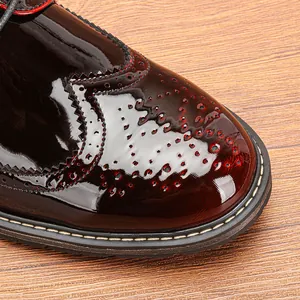 Primer plano de elegante zapato brogue de charol burdeos con finas perforaciones