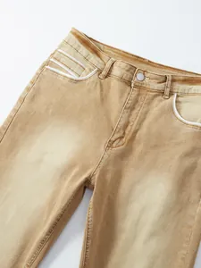 Detailed view of men's khaki stretch denim jeans featuring white piping on front pockets