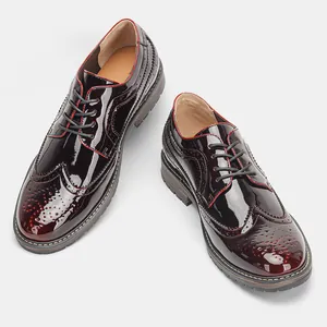Detalle de zapatos Brogue para hombre en charol burdeos con ribete rojo y cordones