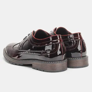 Detalle posterior de zapatos Brogue de hombre en charol brillante con perforaciones