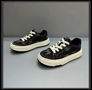 Detailed view of men's chunky black canvas sneakers with patterned upper and white sole.