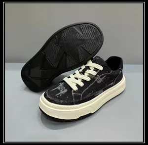Detail view of men's chunky denim sneakers featuring animal prints and cream platform sole