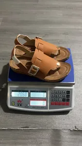 Close-up showing the lightweight design of brown rhinestone wedge sandals on a scale