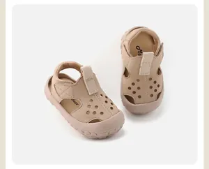 Detail of breathable hollow beige leather toddler sandals with a secure velcro strap