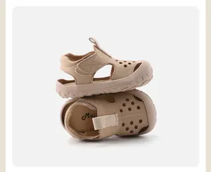 Detailed macro view of beige toddler sandals with hollow holes and soft protective toe cap
